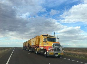 A big yellow moving truck on the road